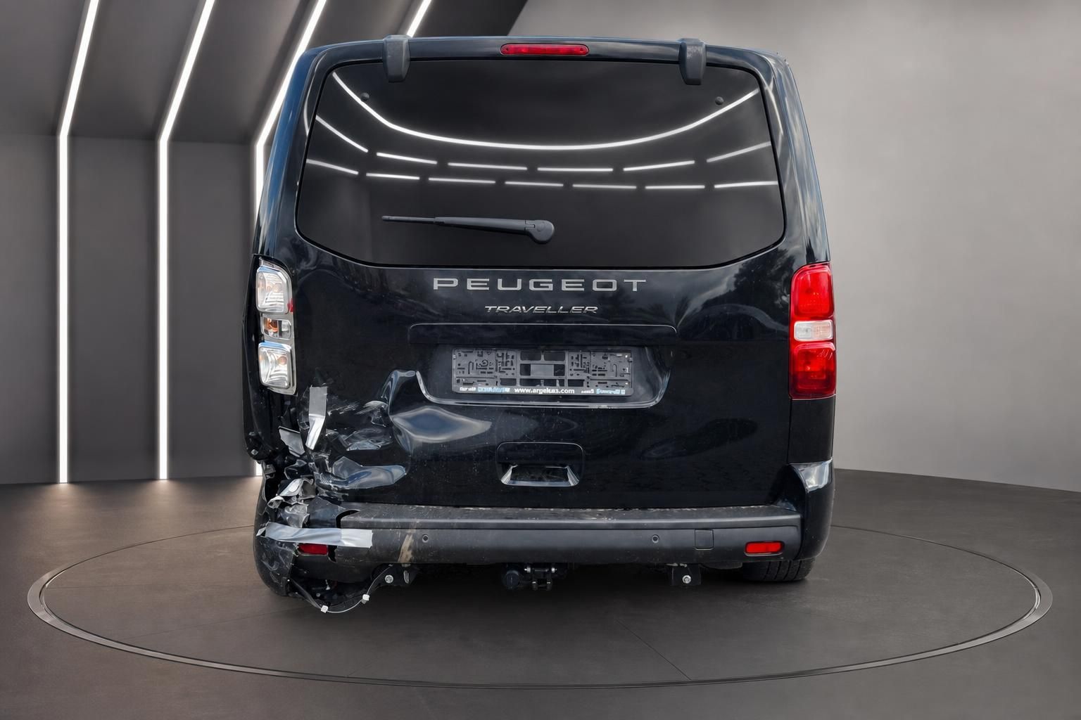 Heckansicht des schwarzen Peugeot Traveller mit sichtbaren Unfallschäden und Anhängerkupplung