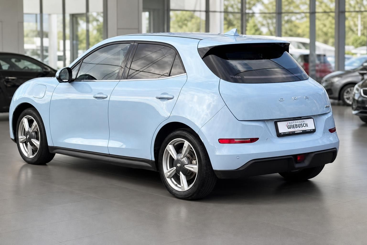Hellblauer ORA Elektro-SUV Heckansicht mit Händlerkennzeichen im Autohaus