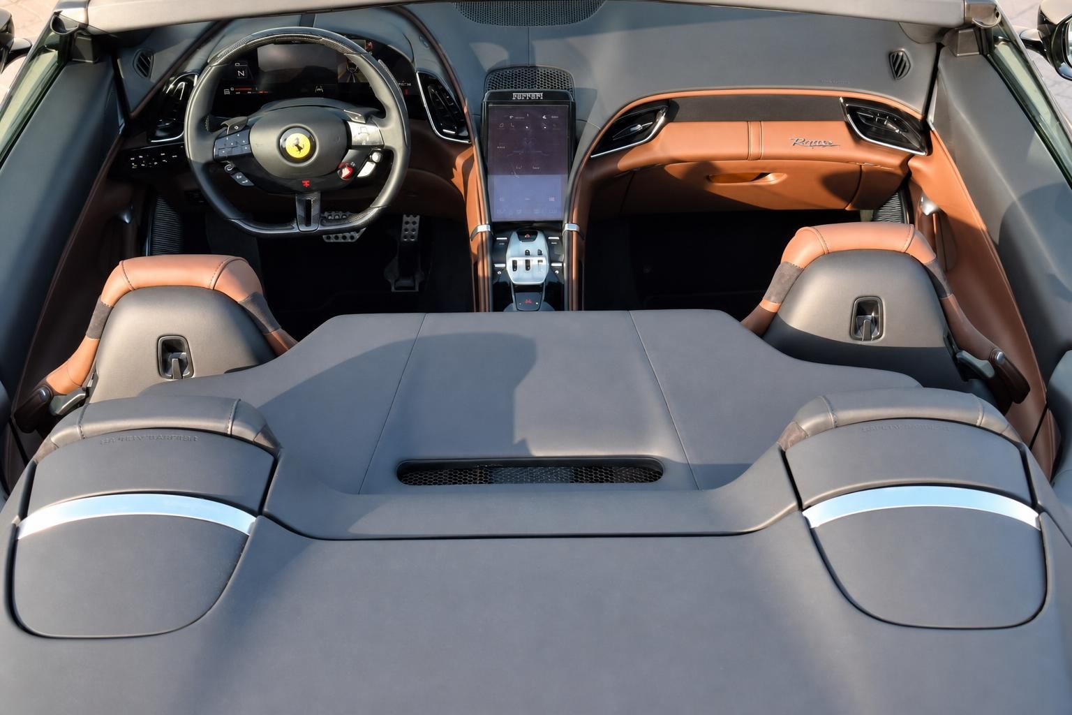 Ferrari Cabrio Innenraum mit grauen und orangen Ledersitzen sowie Touchscreen-Display