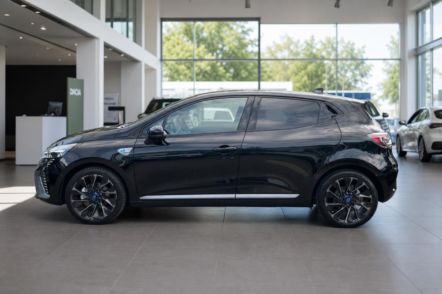 Schwarzer Renault Clio Seitenansicht - Komplettansicht mit Profil und Sportfelgen im Showroom
