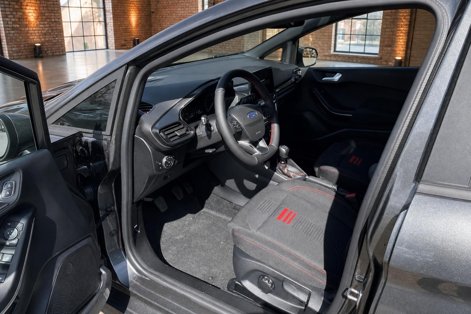 Ford Fiesta Innenraum Fahrerseite mit Sportlenkrad, Schalthebel und roten Sitzdetails