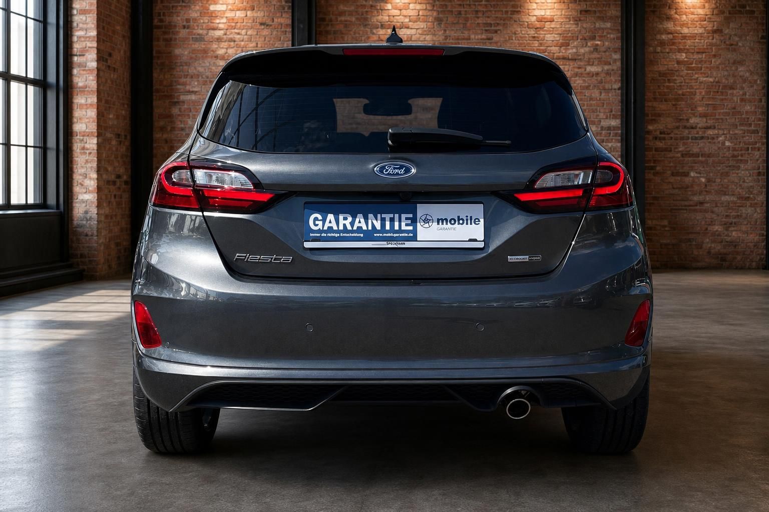 Ford Fiesta grau Heckansicht mit Rückleuchten und Fiesta-Schriftzug in Industriehalle