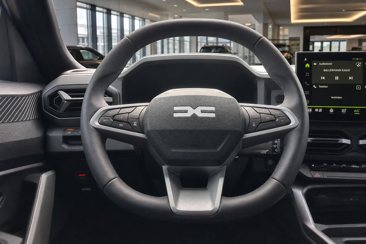 Fahrzeug Lenkrad mit Multifunktionstasten und Touchscreen Display im Hintergrund
