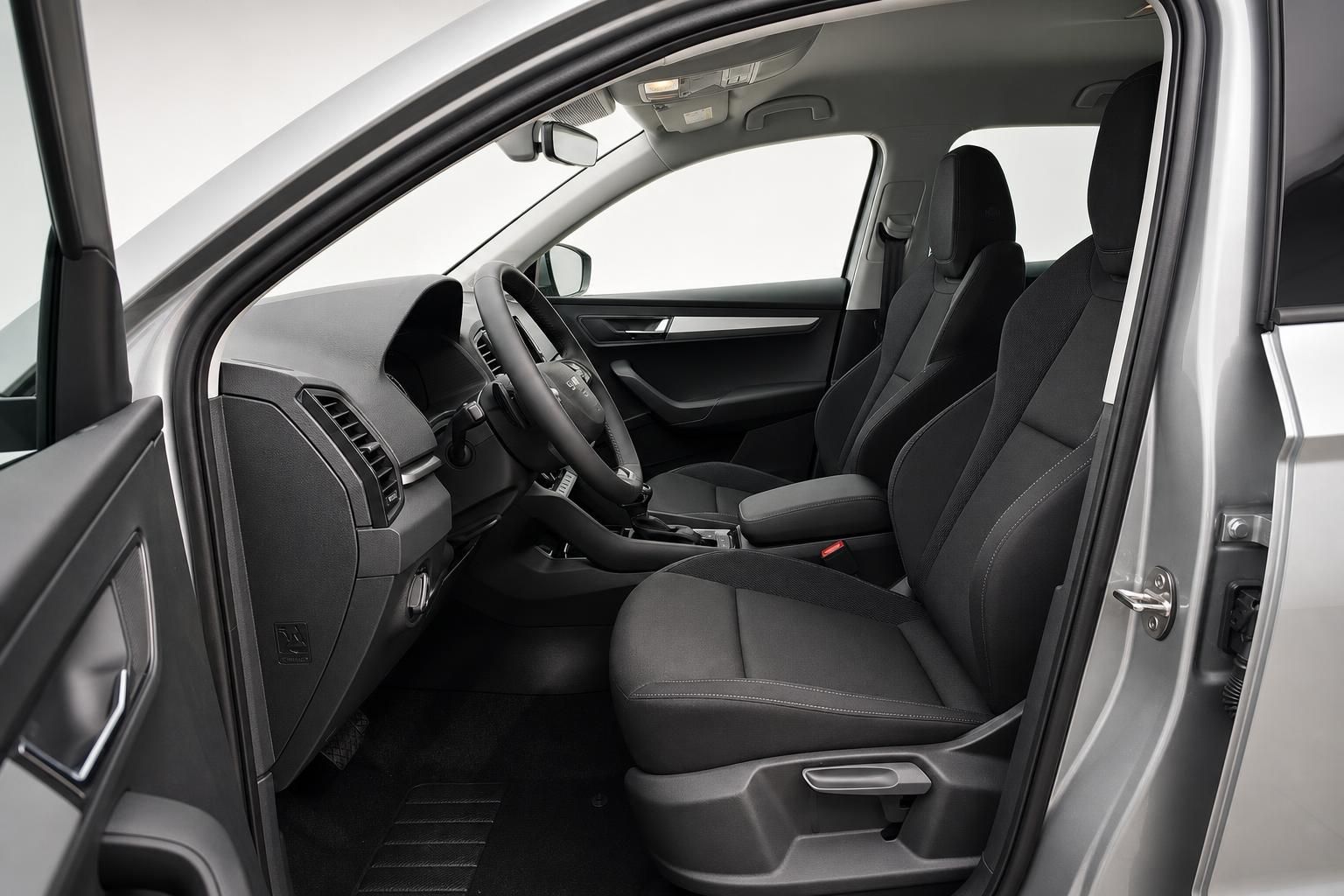 Skoda Karoq Innenraum mit Vordersitzen und Armaturenbrett, Fahrertuere geoeffnet