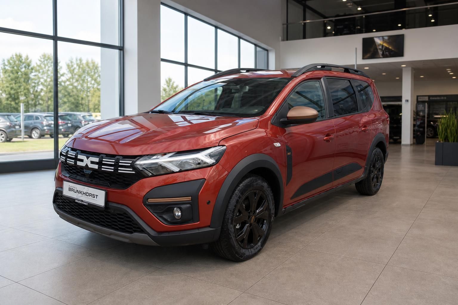 Roter Dacia SUV Seitenansicht im hellen Autohaus Showroom mit großen Fenstern
