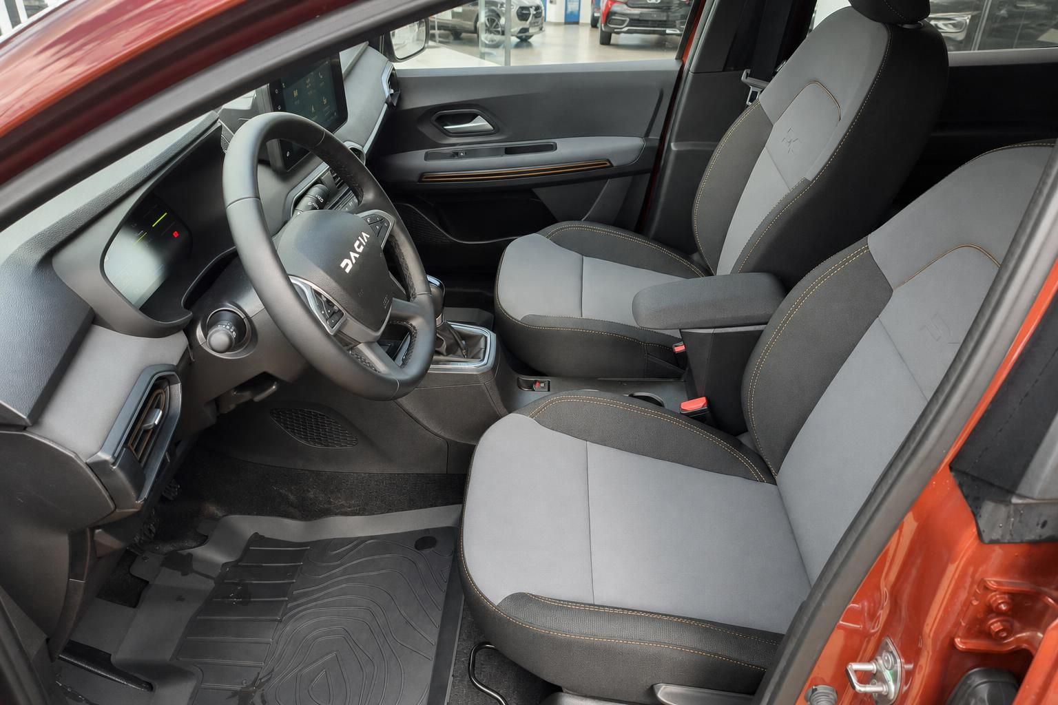 Dacia Innenraum mit grau-schwarzen Sitzen, Lenkrad und Armaturenbrett im Autohaus