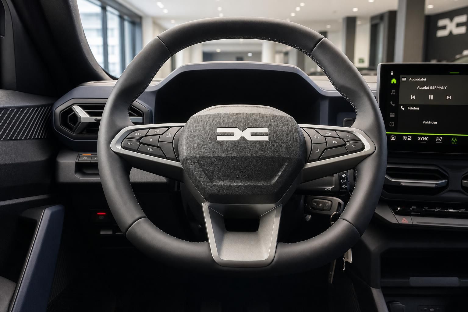 Lenkrad mit Multifunktionstasten und Infotainment-Display im Cockpit