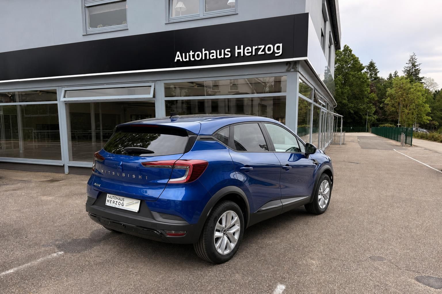 Blauer Mitsubishi SUV Heckansicht vor Autohaus mit LED-Rückleuchten und Modellschriftzug