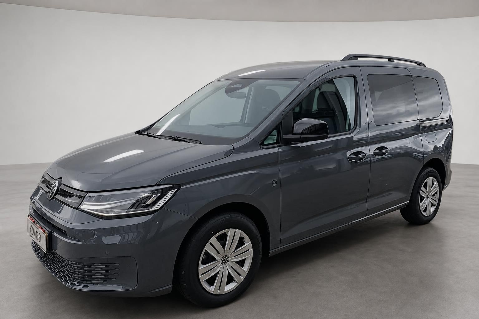 VW Caddy grau, Frontansicht schraeg im Studio