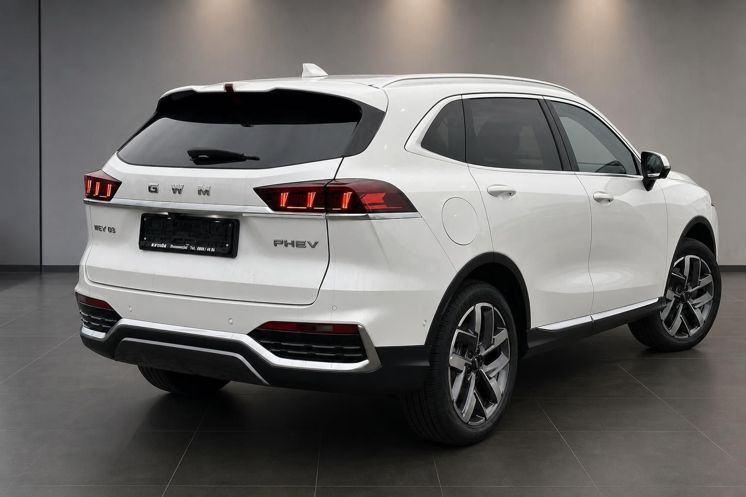 GWM WEY 03 PHEV weiss schraege Heckansicht rechts im Showroom
