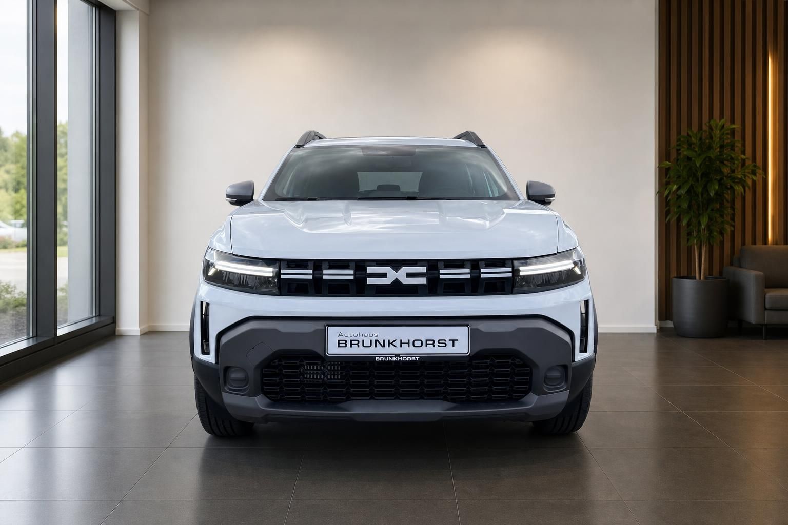 Dacia Duster SUV in weiß, Frontansicht mit LED-Scheinwerfern im Showroom
