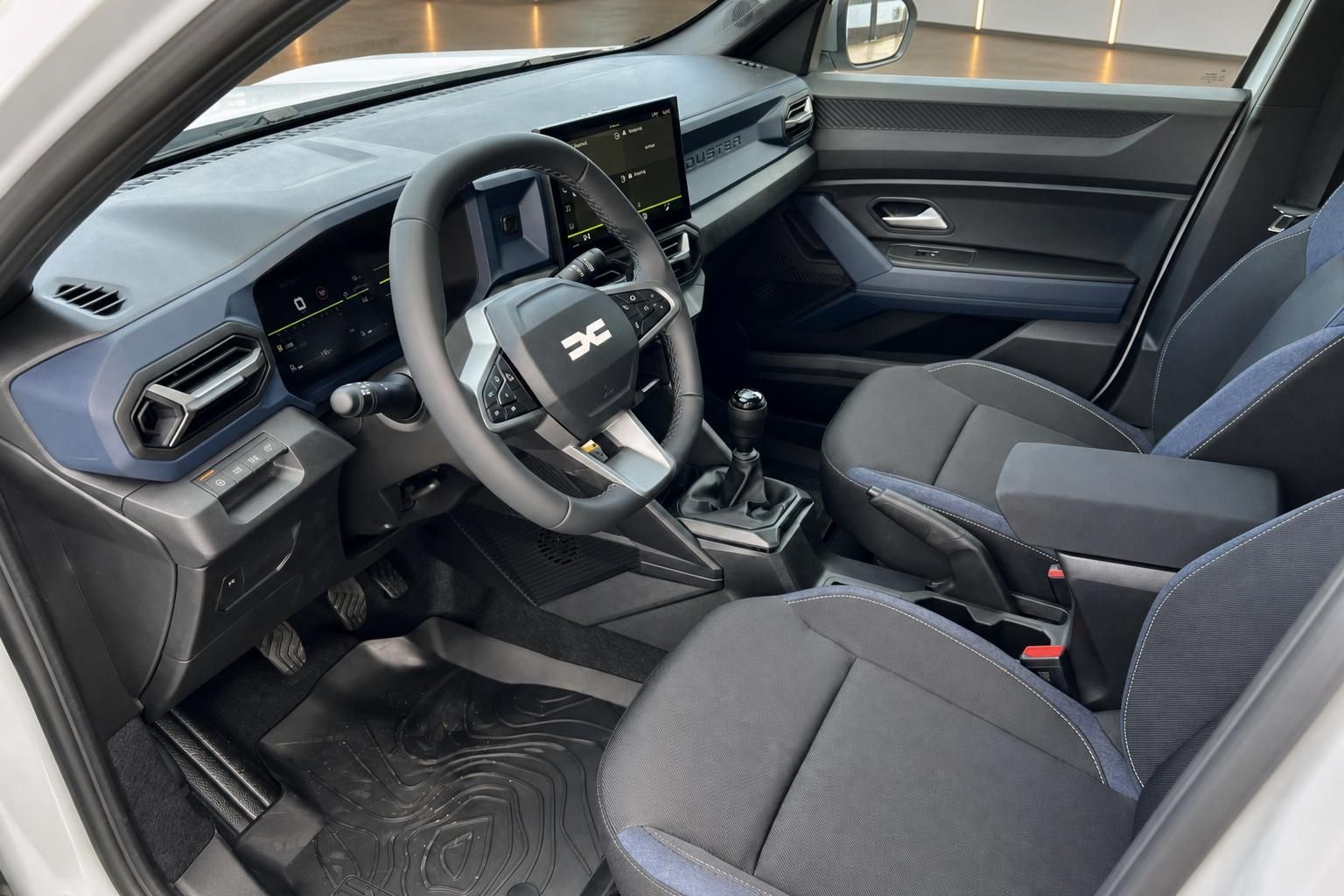 Dacia Duster Innenraum mit Schaltgetriebe, Touchscreen und blauer Ziernähten