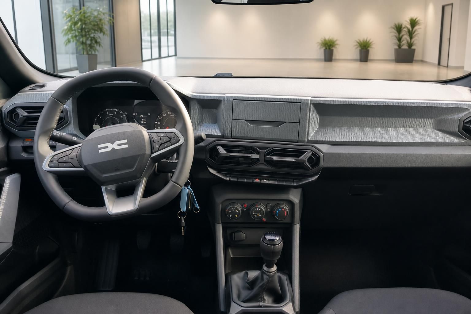 Dacia SUV Innenraum mit schwarzem Armaturenbrett, Lenkrad und manueller Schaltung