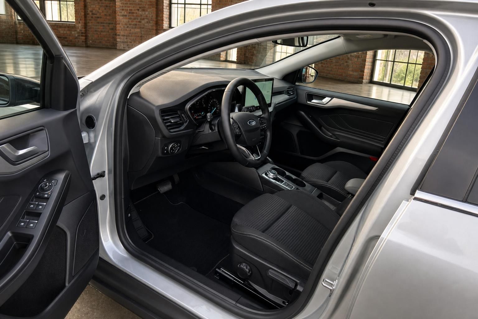 Ford Focus Innenraum mit Cockpit, Lenkrad und Fahrersitz bei geoeffneter Tuer