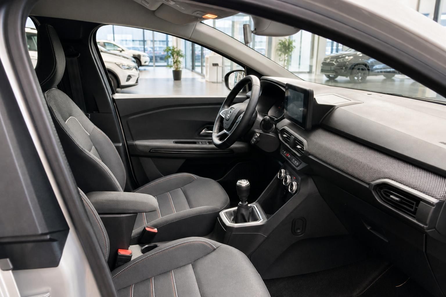 Innenraum Dacia mit Vordersitzen, Lenkrad und Schaltknauf
