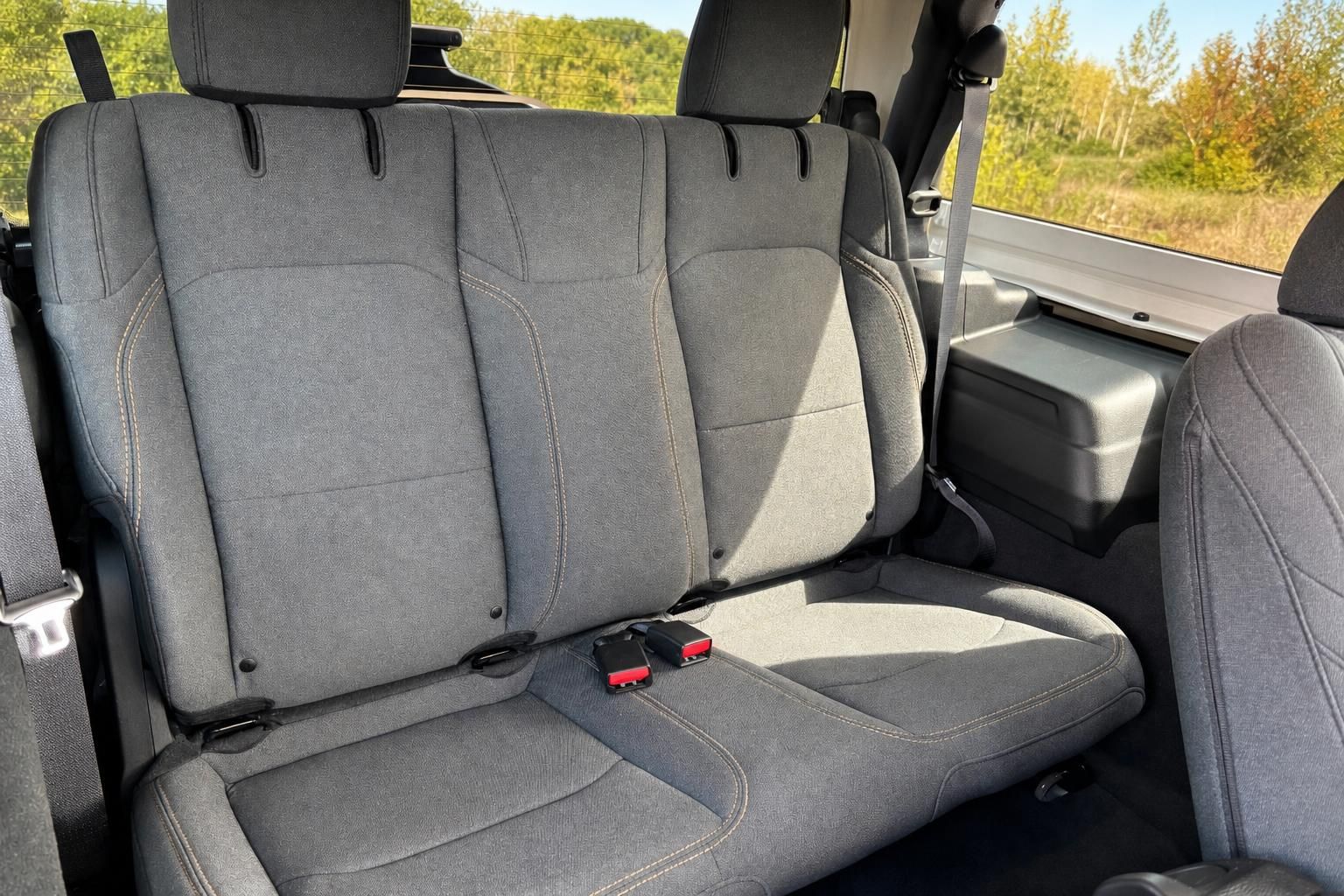 Jeep Fahrzeug Innenraum Rücksitze grau mit Sicherheitsgurten und Ausblick durch Fenster