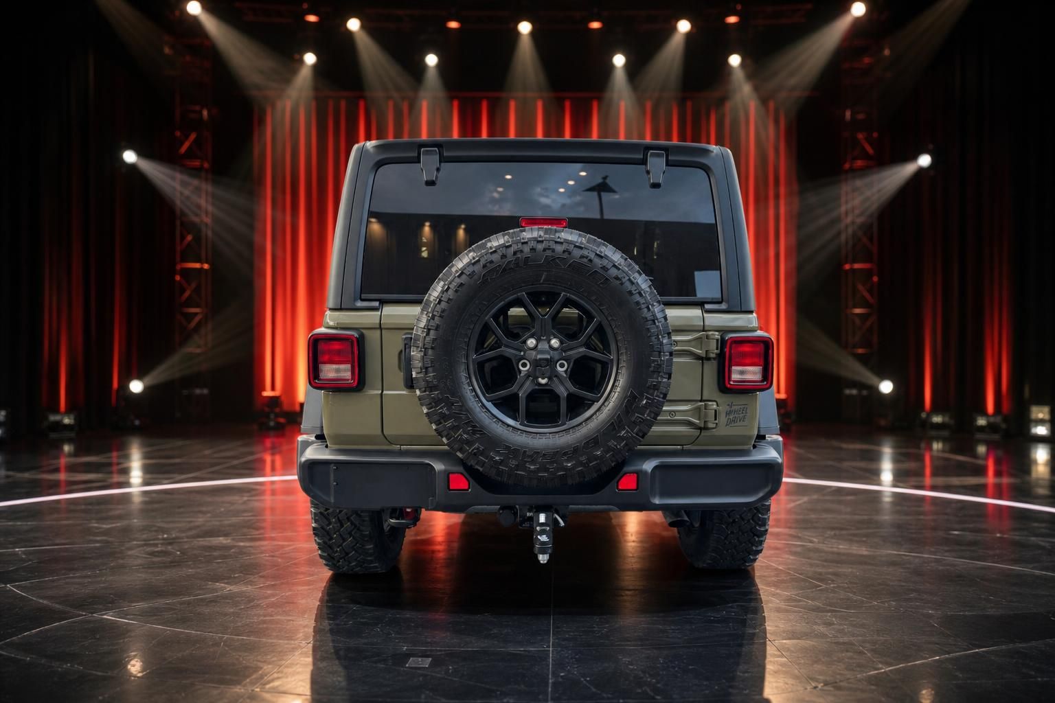 Jeep Wrangler Heckansicht mit Reserverad und schwarzen Felgen vor roter Bühnenwand