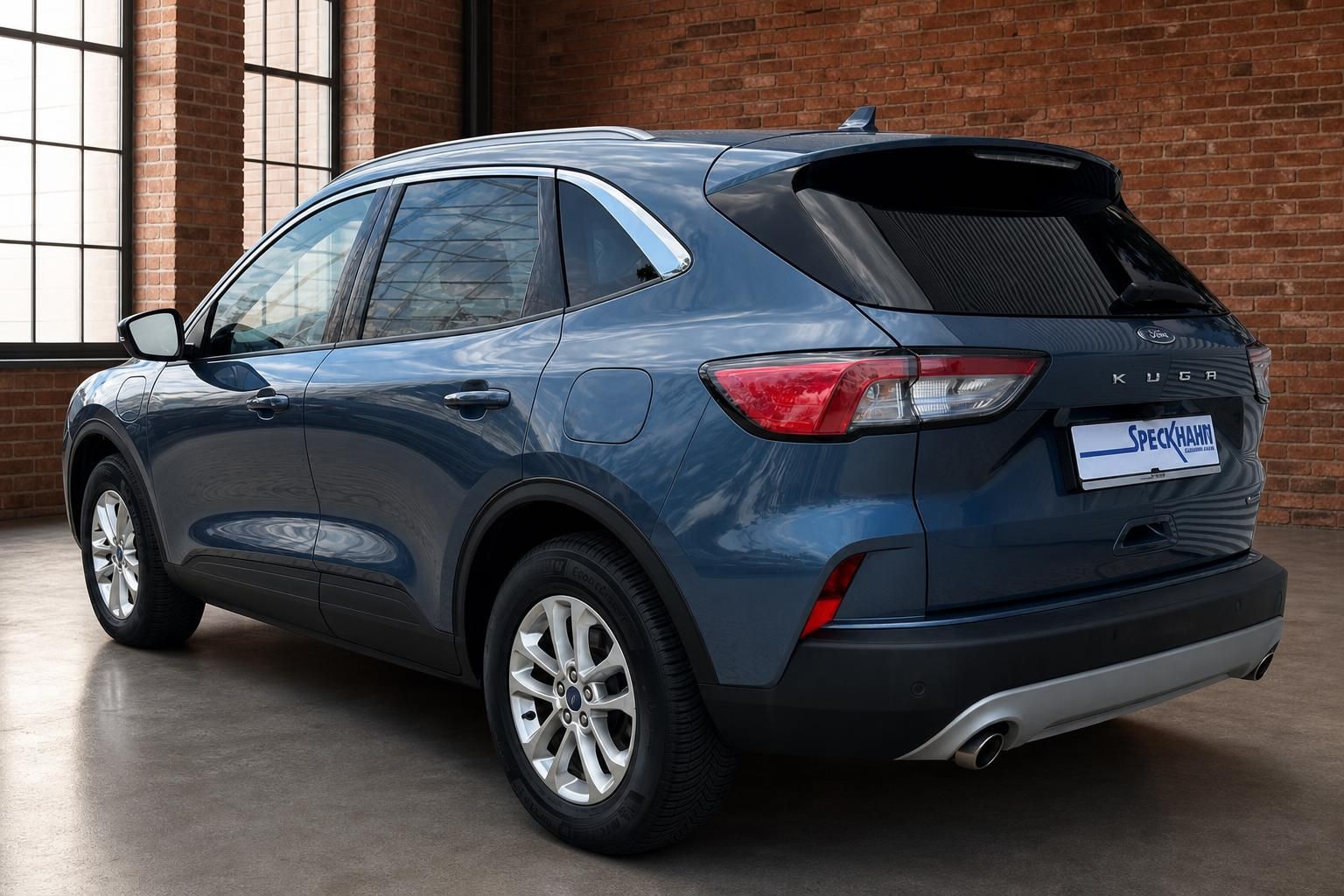 Ford Kuga blau Heckansicht schraeg vor Backsteinwand