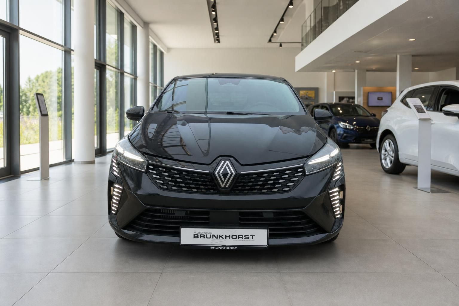 Schwarzer Renault Clio Frontansicht mit charakteristischem Kühlergrill im Showroom