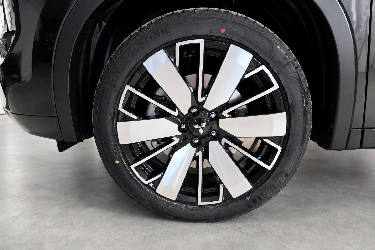 Detailansicht des Leichtmetallfelgen mit Mitsubishi-Logo am Fahrzeug