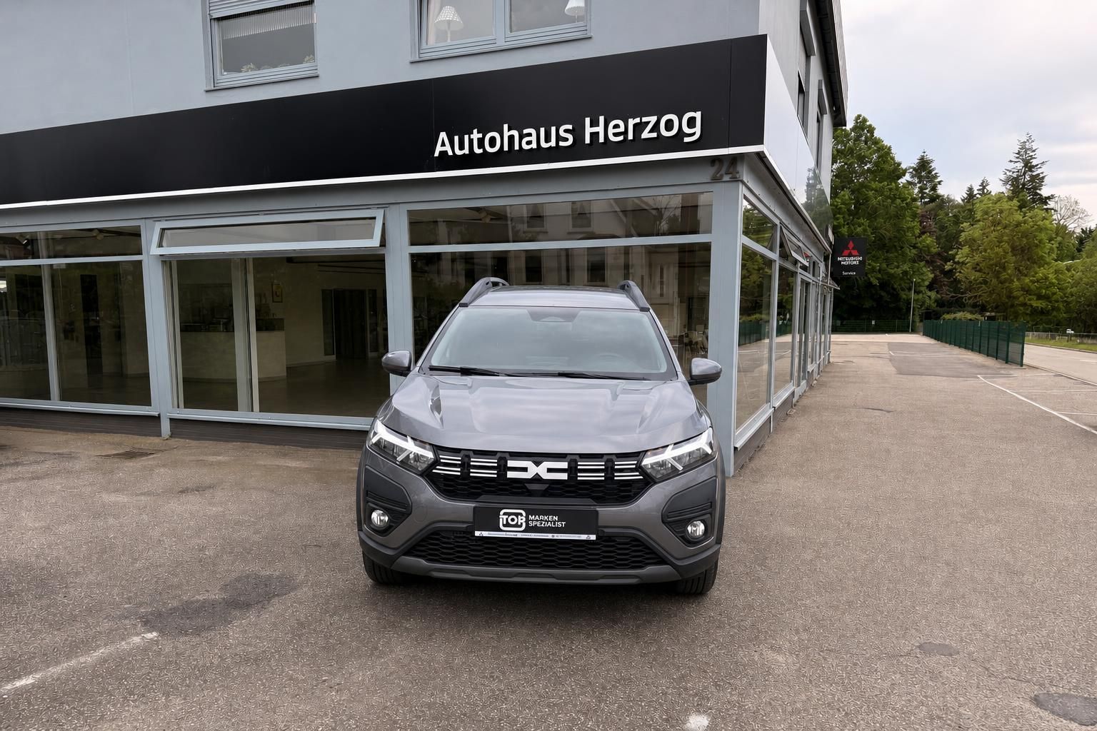 Dacia SUV Frontansicht grau metallic vor Autohaus - kompakter Crossover mit markanter Front
