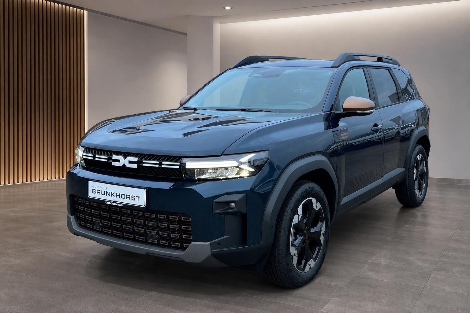 Dacia SUV in dunkelblau, Schrägansicht von vorne links im Autohaus Brunkhorst Showroom