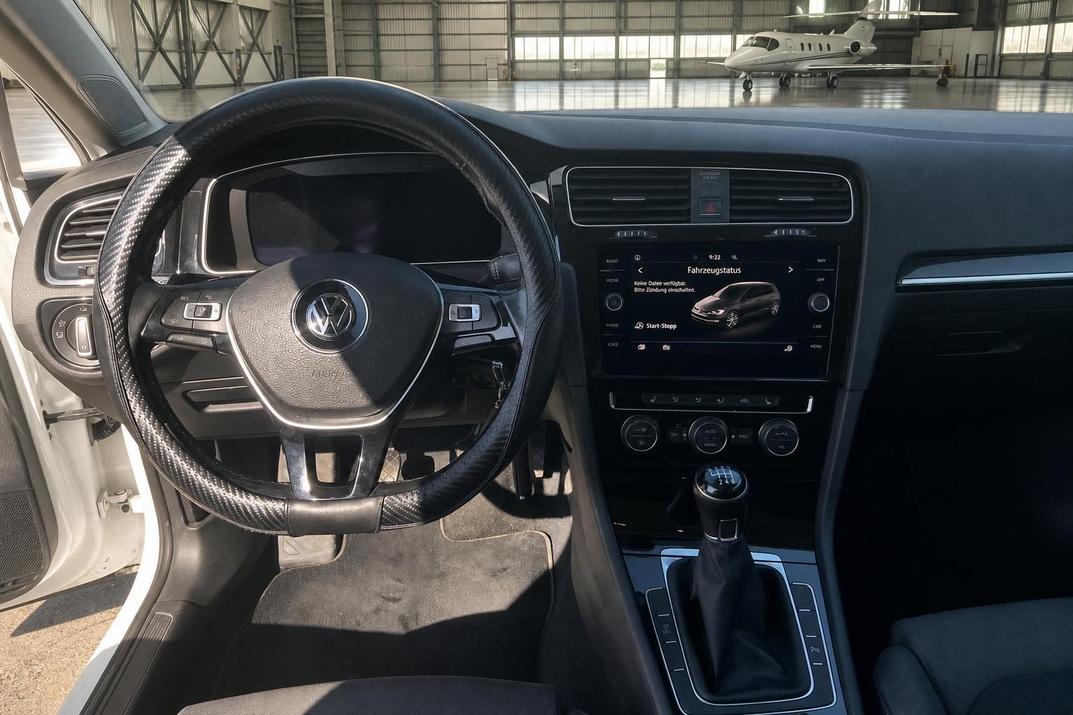 Innenraum Volkswagen Golf mit Lenkrad, Touchscreen und Schaltknauf in schwarzem Design