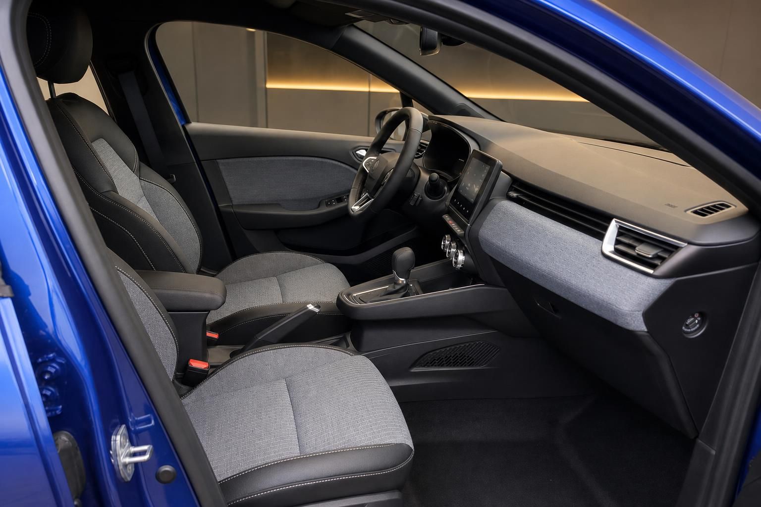 Renault Innenraum mit grauem Stoff, Lenkrad, Armaturenbrett und modernem Infotainment-System