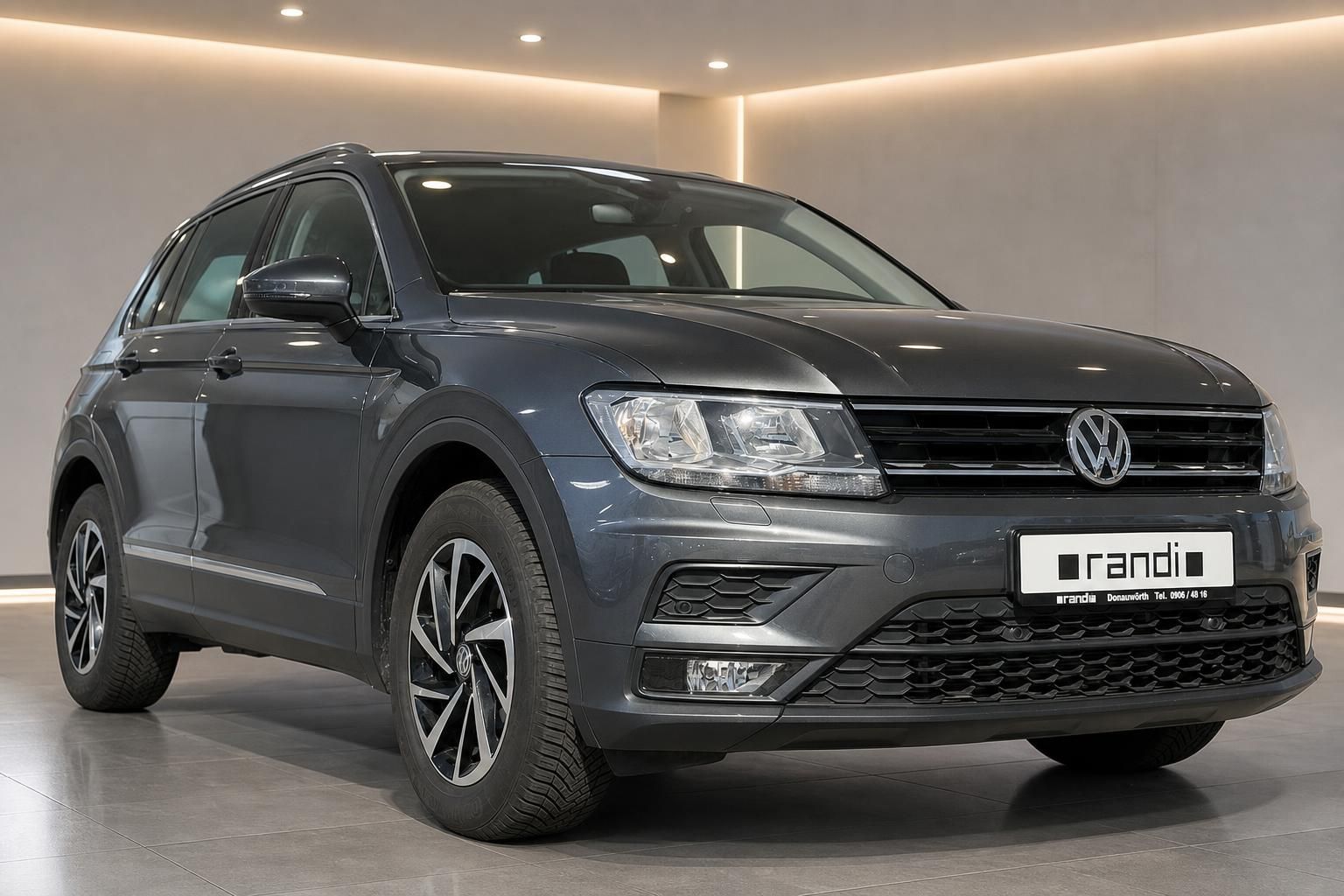 VW Tiguan grau Schrägansicht vorne links im Autohaus – SUV Gebrauchtwagen