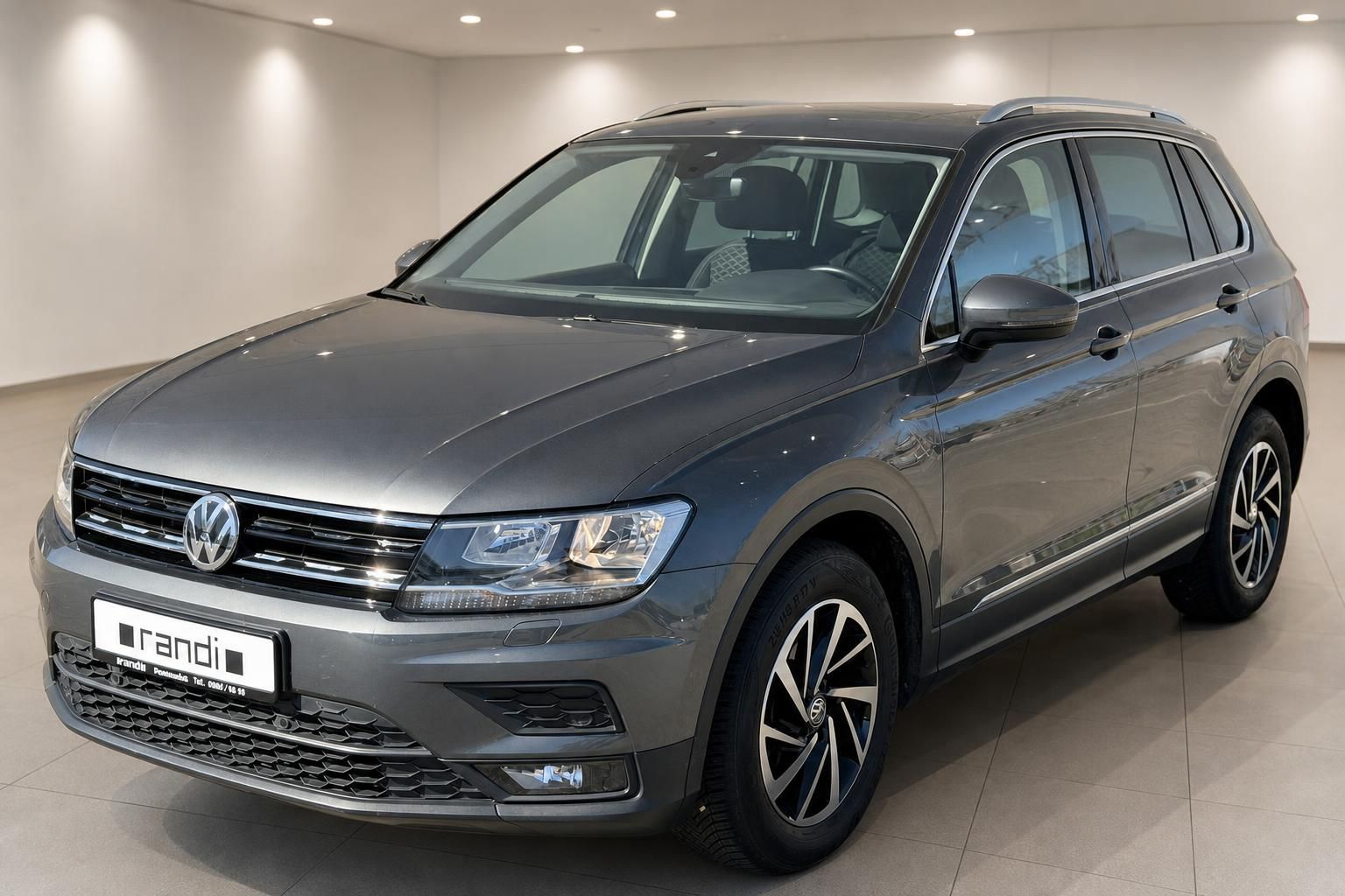VW Tiguan grau Schrägansicht vorne rechts im Autohaus – SUV Gebrauchtwagen