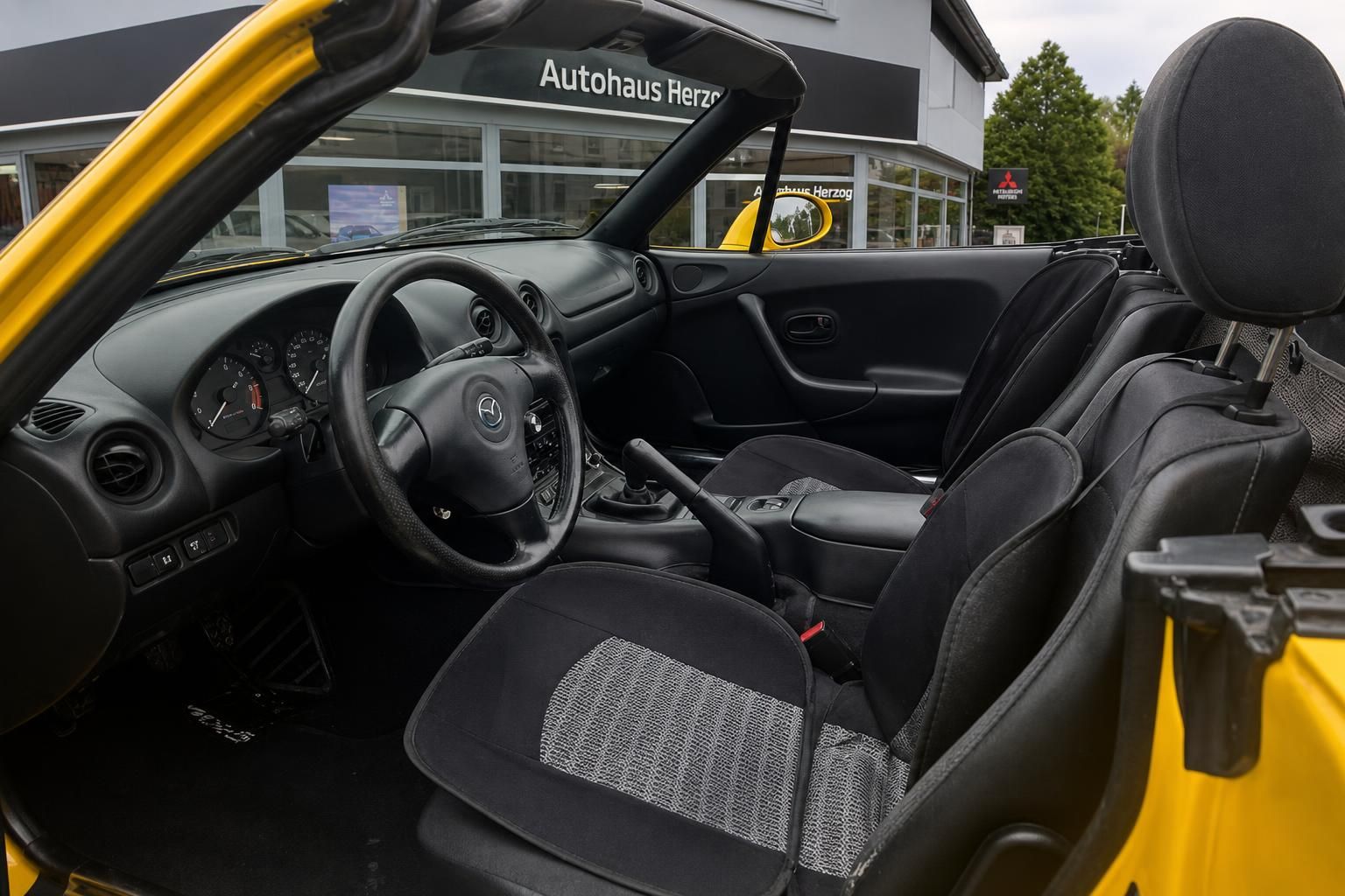 Mazda MX-5 Innenraum mit schwarzen Sitzen und offenem Verdeck - Roadster Interieur