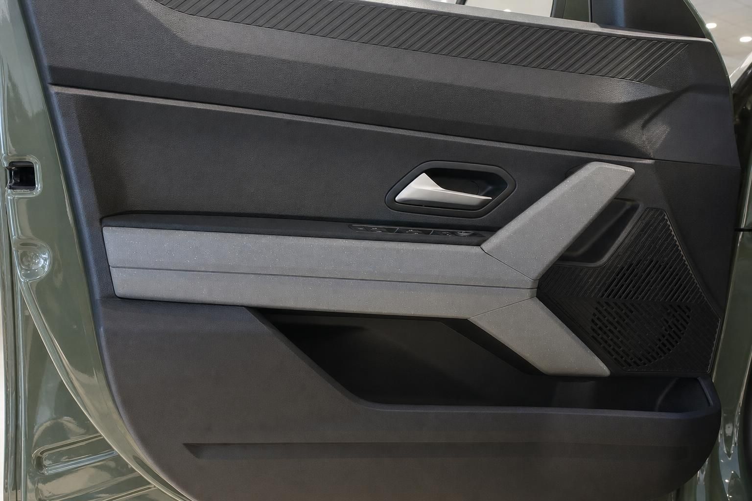 Türverkleidung Innenraum eines grünen SUV mit Türgriff, Lautsprecher und grauem Dekor-Element