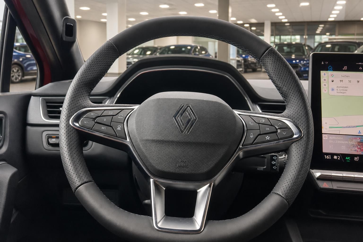 Renault Lenkrad mit Logo und Multifunktionstasten sowie Touchscreen-Infotainment im Autohaus