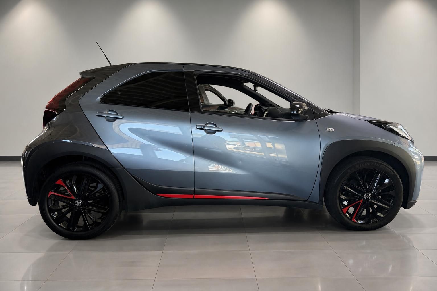 Toyota Aygo X in Grau-Metallic Seitenansicht mit roten Akzenten