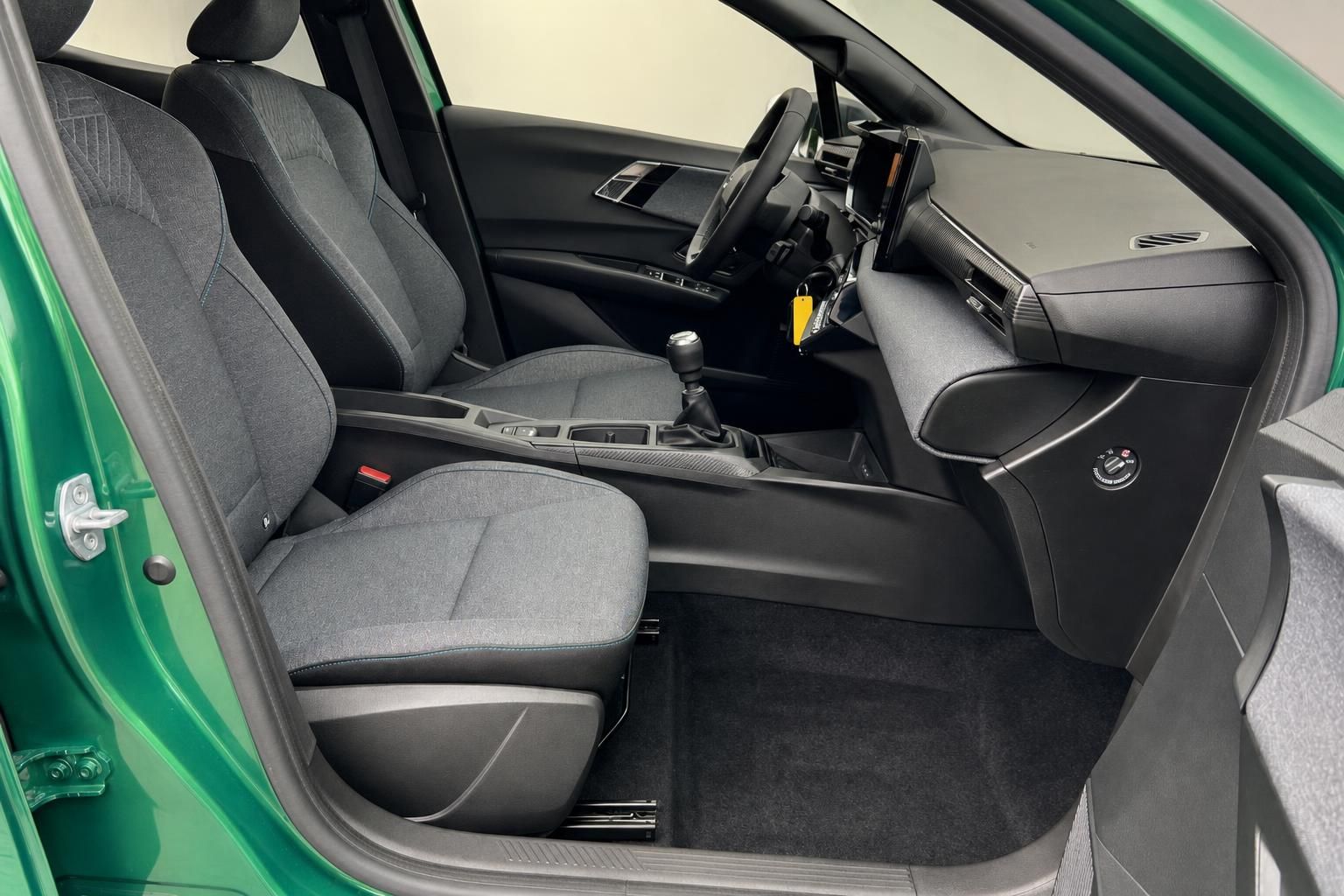 Vorderer Innenraum mit Sitzen und Schaltknauf in grünem Fahrzeug