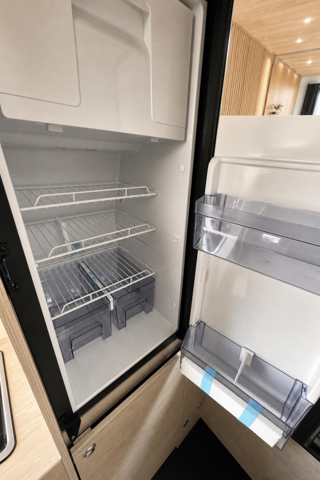 Offener Kuehlschrank im Wohnmobil mit Ablagefaechern