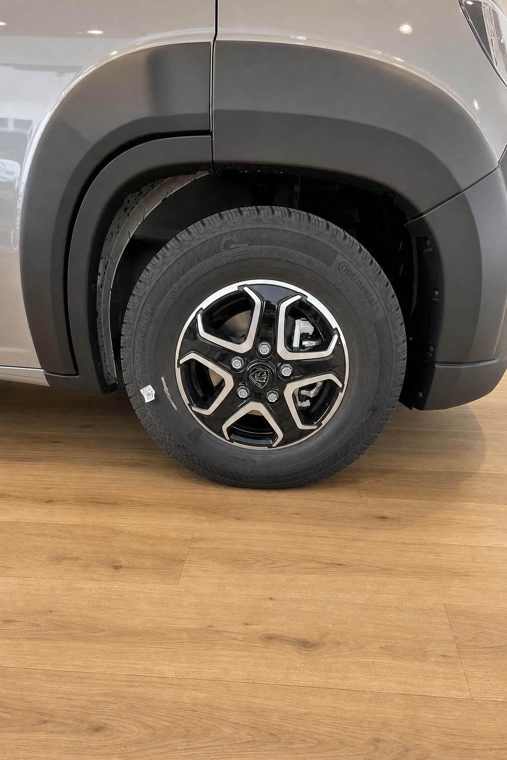 Nahaufnahme Alufelge und Reifen eines Fahrzeugs im Autohaus