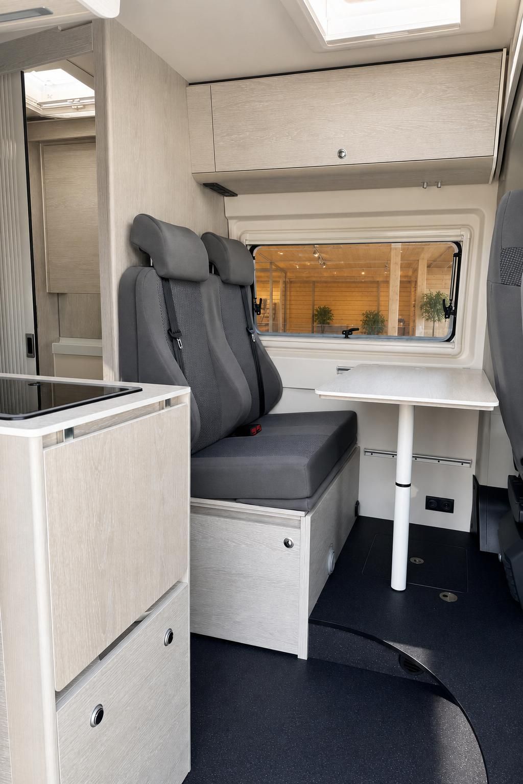 Wohnbereich im Campervan mit Sitzgruppe, Tisch und Fenster