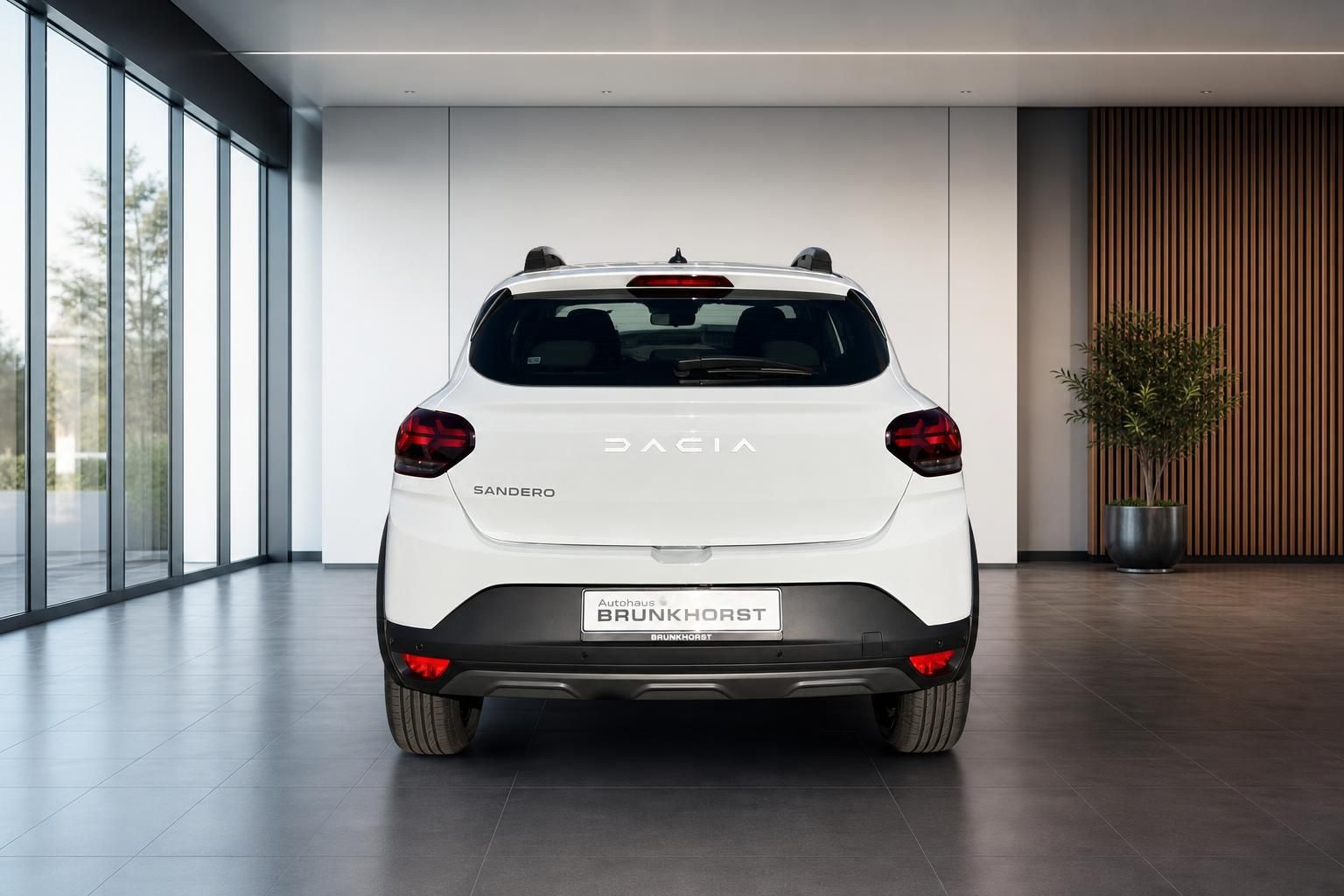Weißer Dacia Sandero Heckansicht im modernen Autohaus mit großen Fenstern und stilvoller Einrichtung