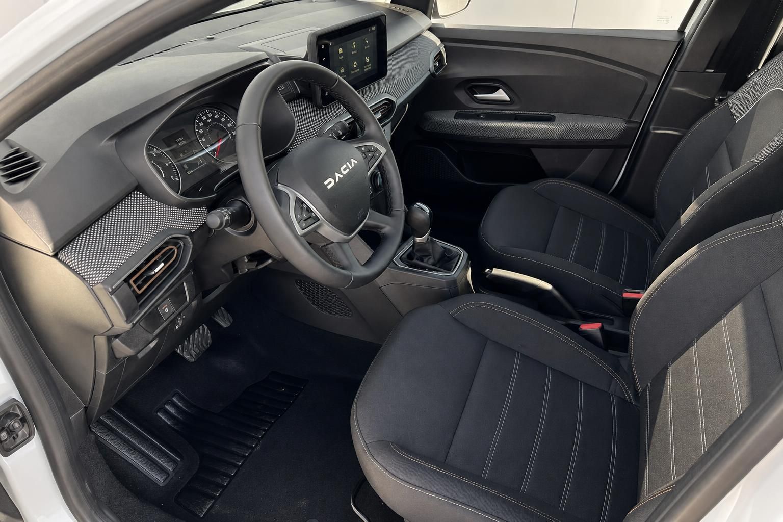 Dacia Innenraum mit schwarzen Sportsitzen, modernem Cockpit und Touchscreen-Infotainmentsystem