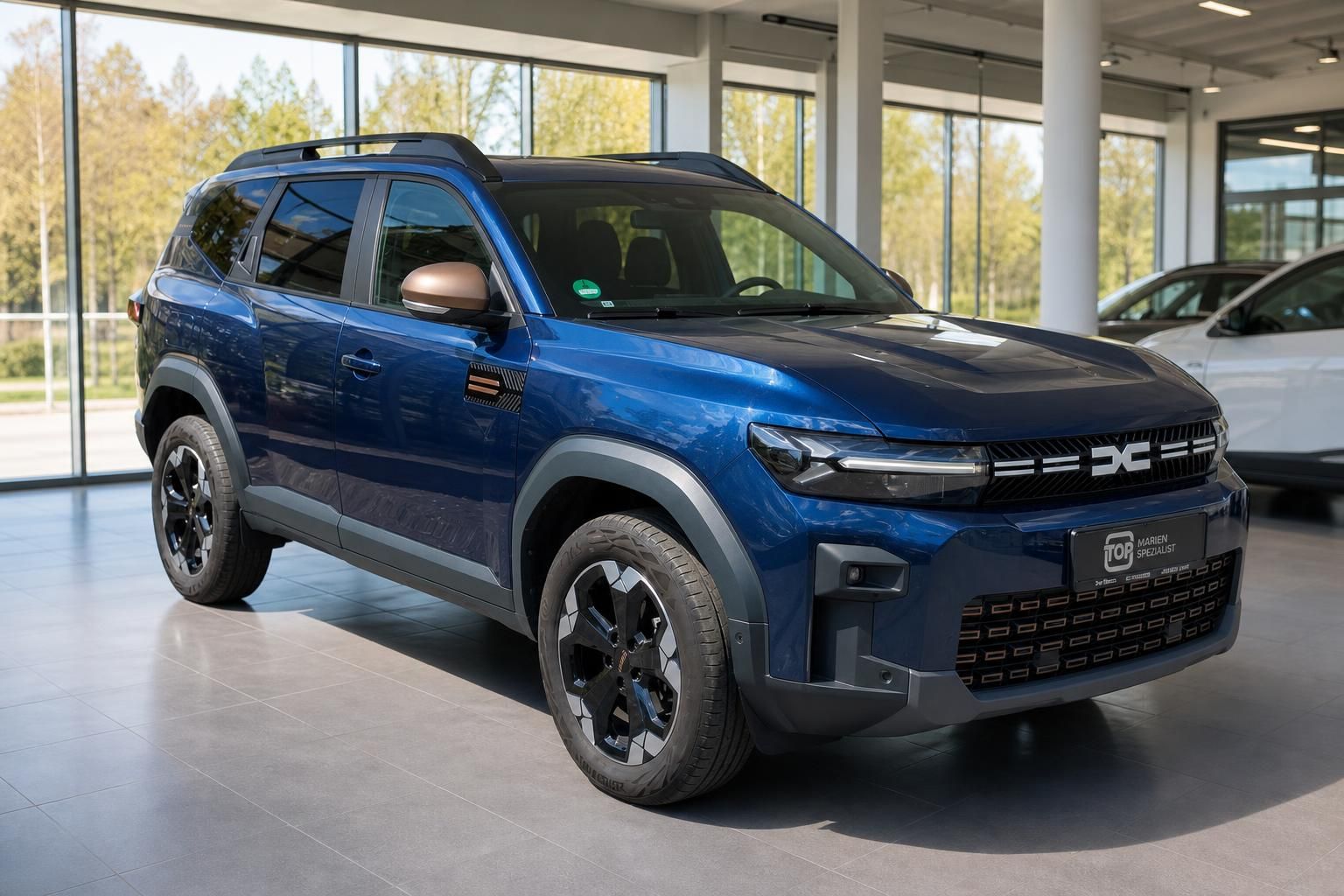 Dacia Bigster blau Frontansicht schräg im Showroom – SUV Neufahrzeug 2025