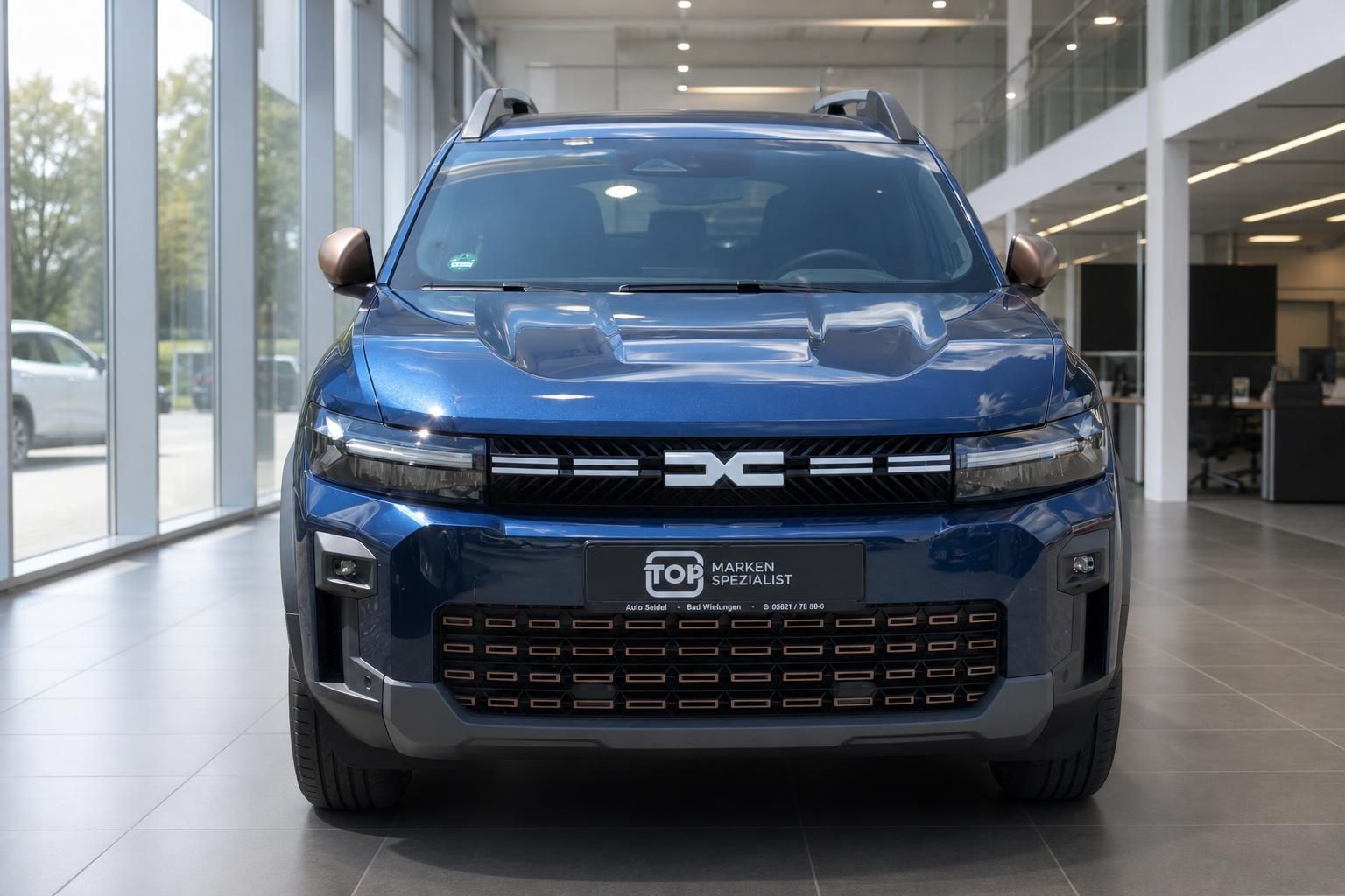 Dacia Bigster blau Frontansicht im Autohaus – SUV mit LED-Scheinwerfern und Dacia-Logo