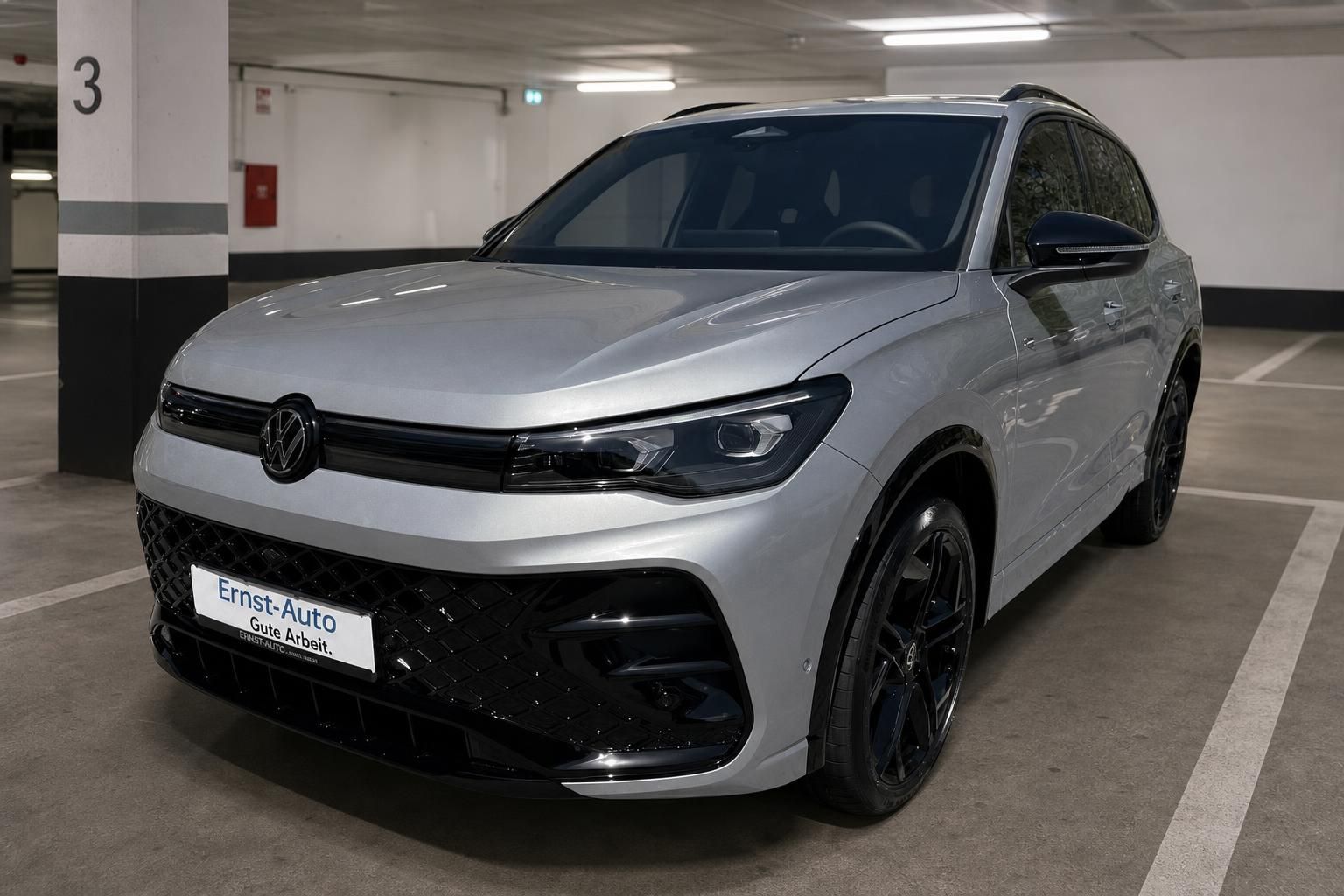 VW Tiguan silber Frontansicht schräg in Parkgarage mit Ernst-Auto Kennzeichen