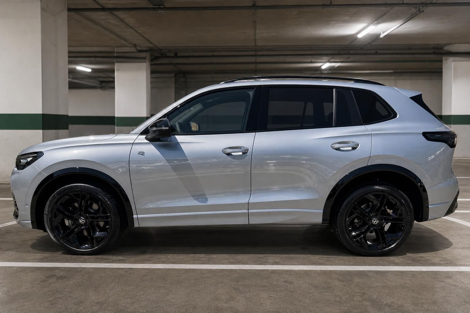VW Tiguan silber Seitenansicht in Tiefgarage mit schwarzen Alufelgen