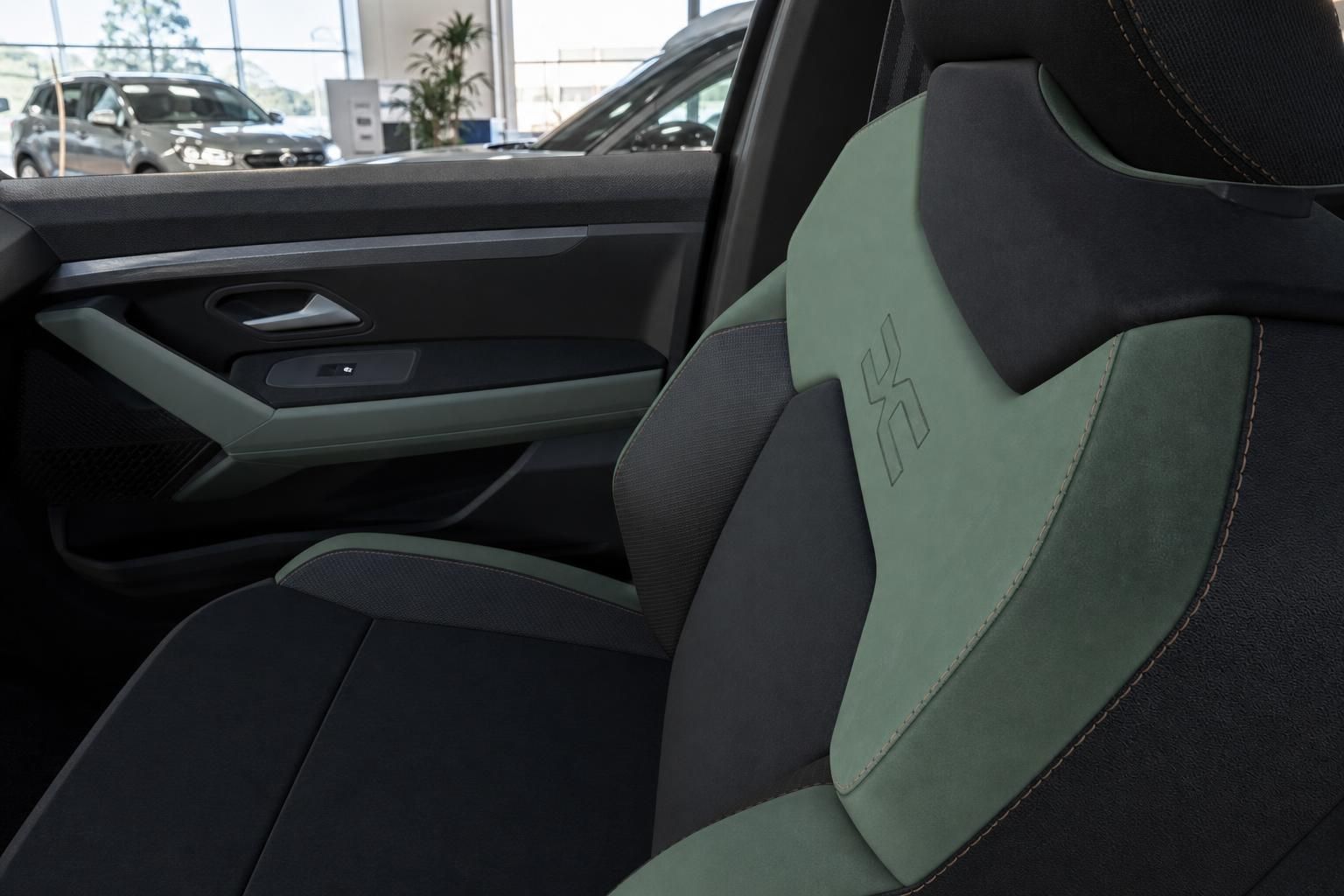 Fahrzeuginnenraum mit grün-schwarzen Sportsitzen und Markenlogo im Autohaus