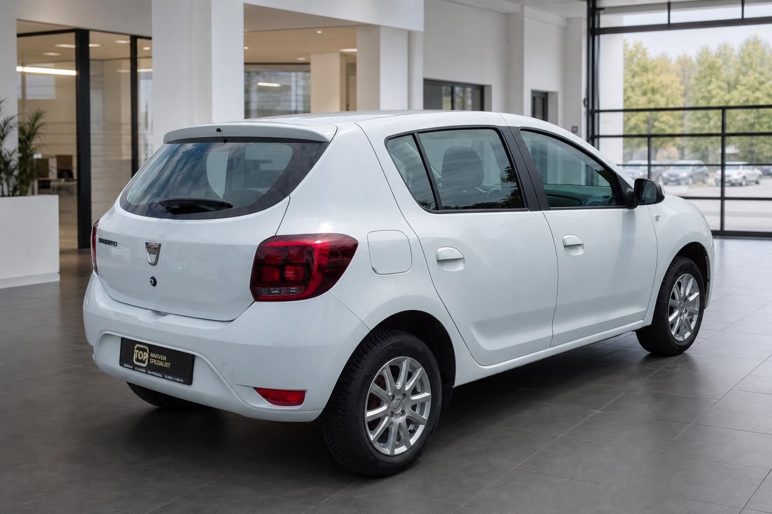Dacia Sandero weiss Heckansicht schraeg links im Autohaus Showroom