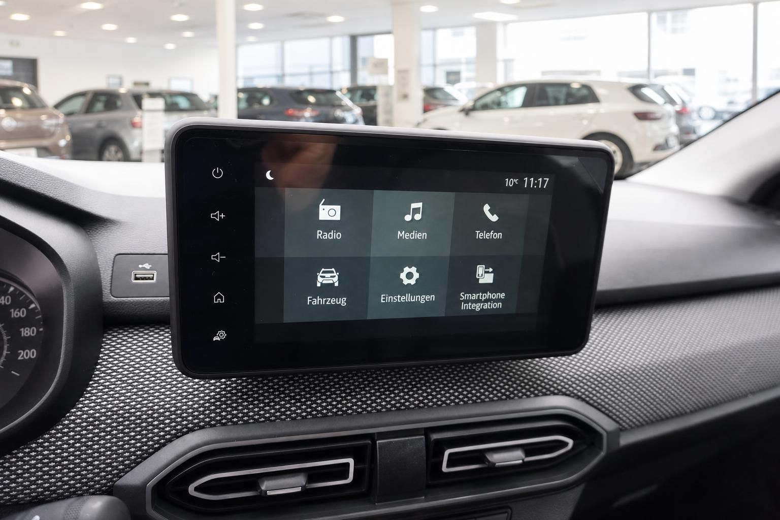 Modernes Infotainment-Display im Fahrzeuginnenraum mit Touchscreen-Menü und Autohaus im Hintergrund