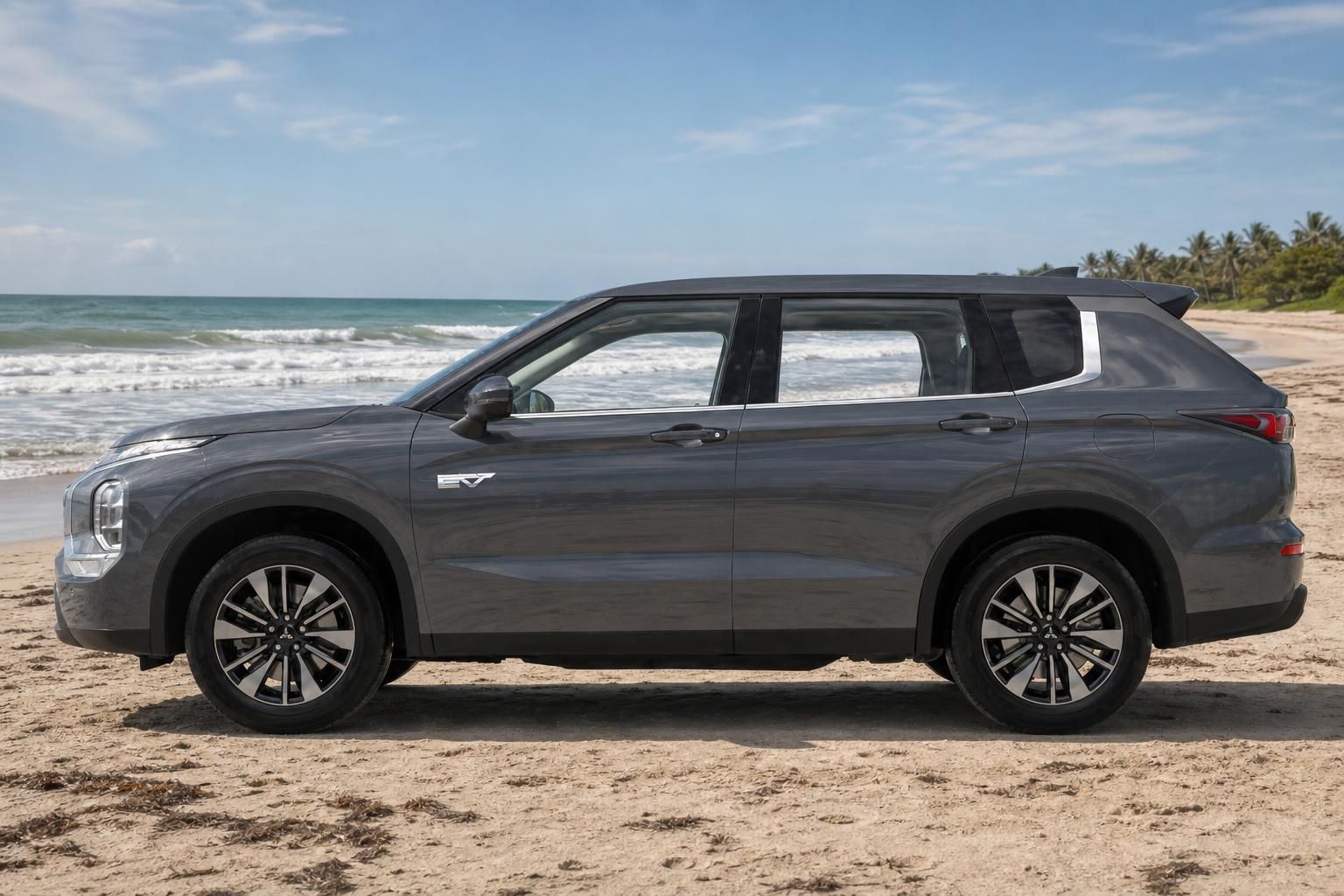 Mitsubishi Outlander EV grau, Seitenansicht am Strand mit Meerblick