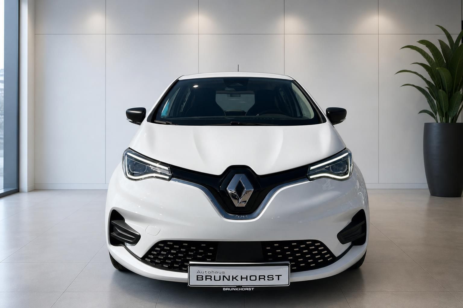 Weißer Renault ZOE Elektroauto Frontansicht im Autohaus Brunkhorst Showroom mit LED-Scheinwerfern