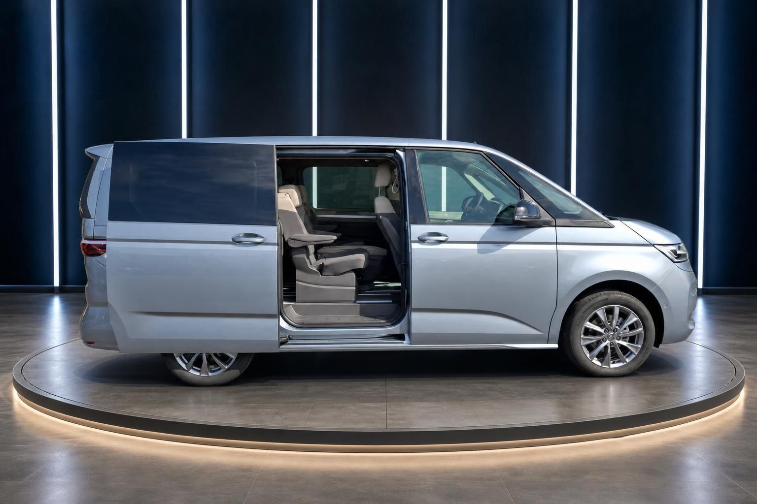 Volkswagen Van silbergrau mit geöffneter Schiebetür - Blick auf komfortable Passagier-Bestuhlung